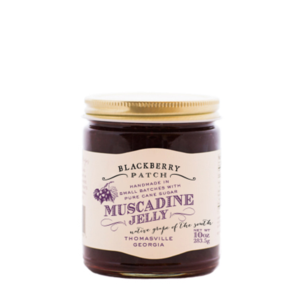10oz jar of Blackberry Patch Muscadine Jelly with gold screw on lid. 