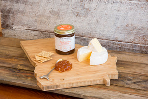 Cheese board with Peach Bourbon Cardamom Fruit Preserves for Cheese and wheel of soft cheese. 