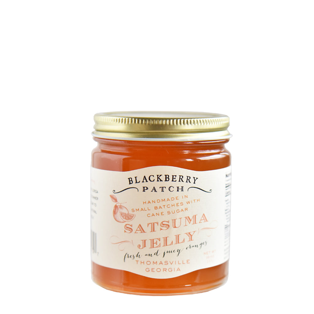 10oz glass jar of Blackberry Patch Satsuma Jelly with gold screw on lid. 