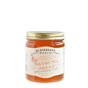 10oz glass jar of Blackberry Patch Satsuma Jelly with gold screw on lid. 